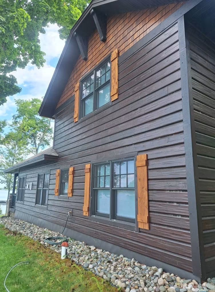 Rich dark siding with cedar shutters, freshly detailed