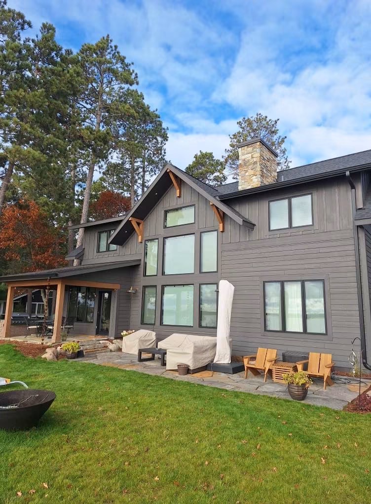 Modern lakeside home with stained siding, professionally maintained