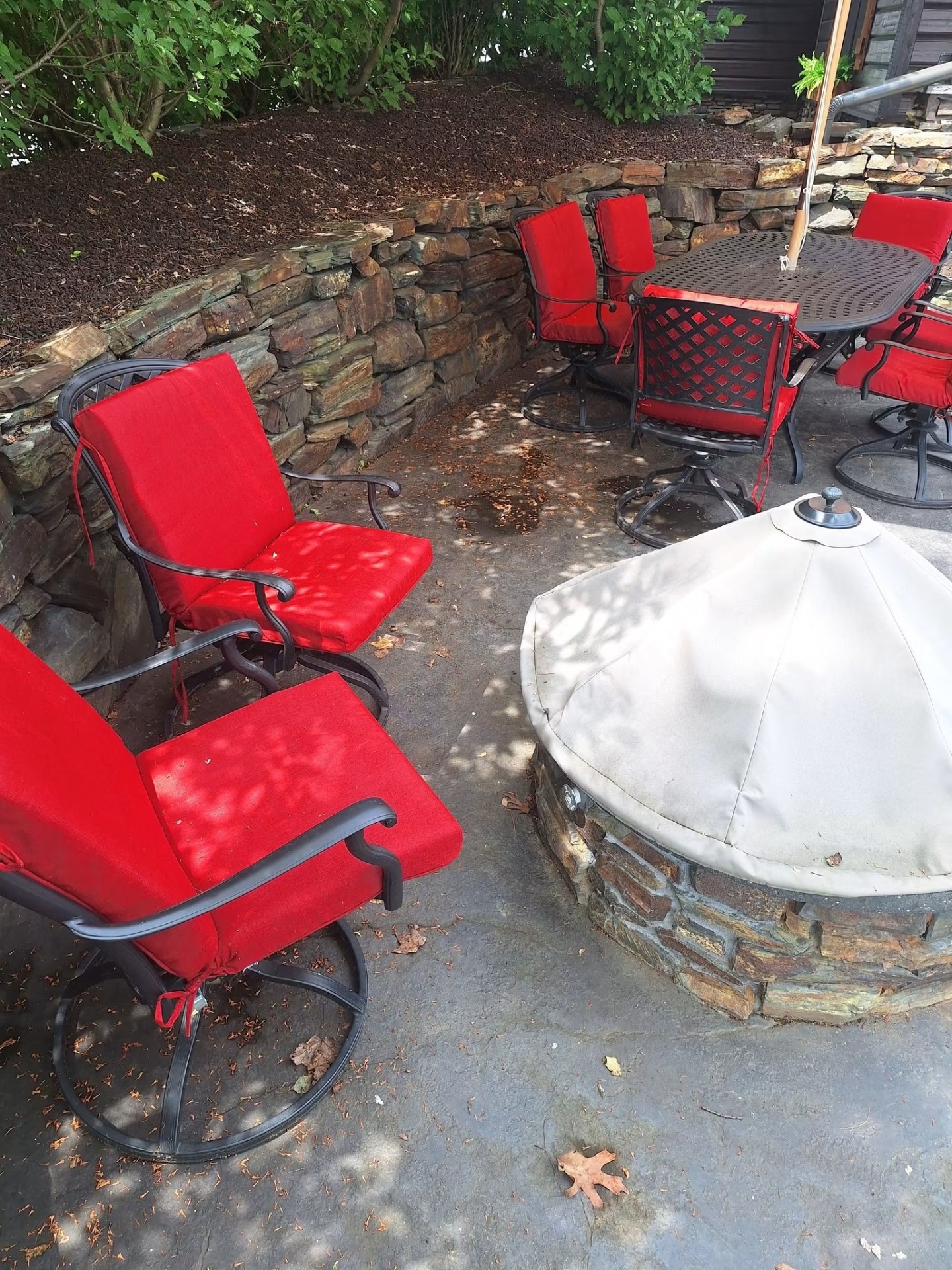 Stone patio with fire pit and lounge seating, freshly cleaned