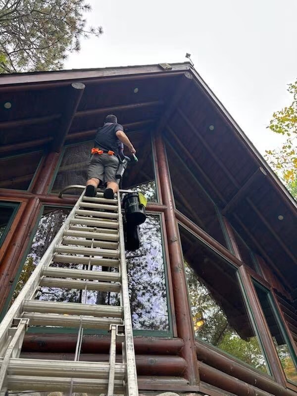 Shane on the ladder washing high cabin windows